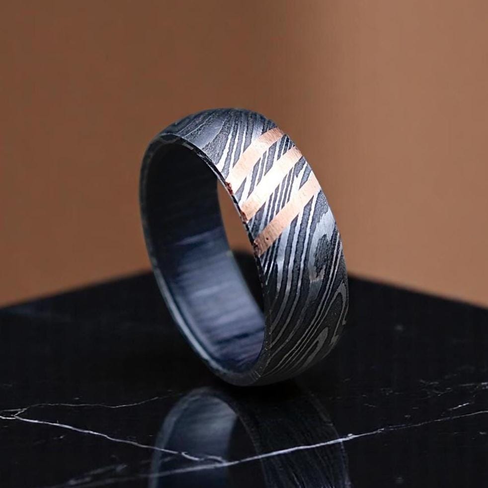 Metallic ring with a marbled pattern on a reflective surface