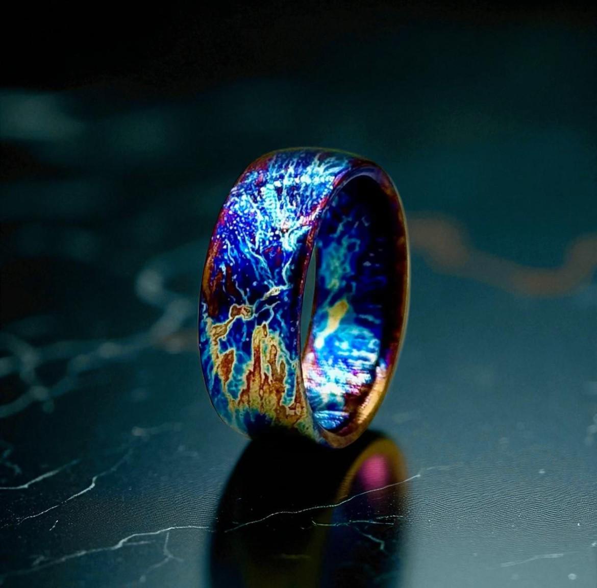 Multicolored ring with a vibrant, iridescent pattern on a dark surface.