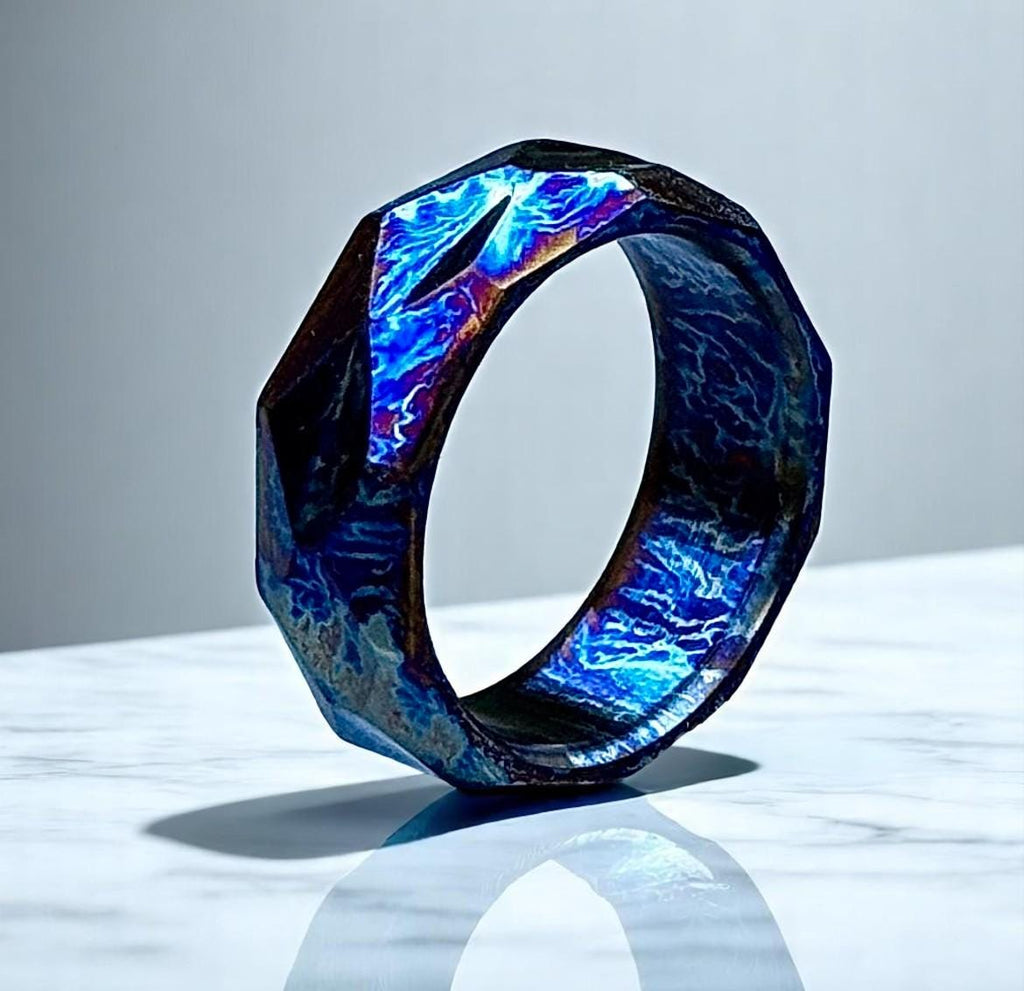 Novelty ring with blue and purple iridescent design on a reflective surface