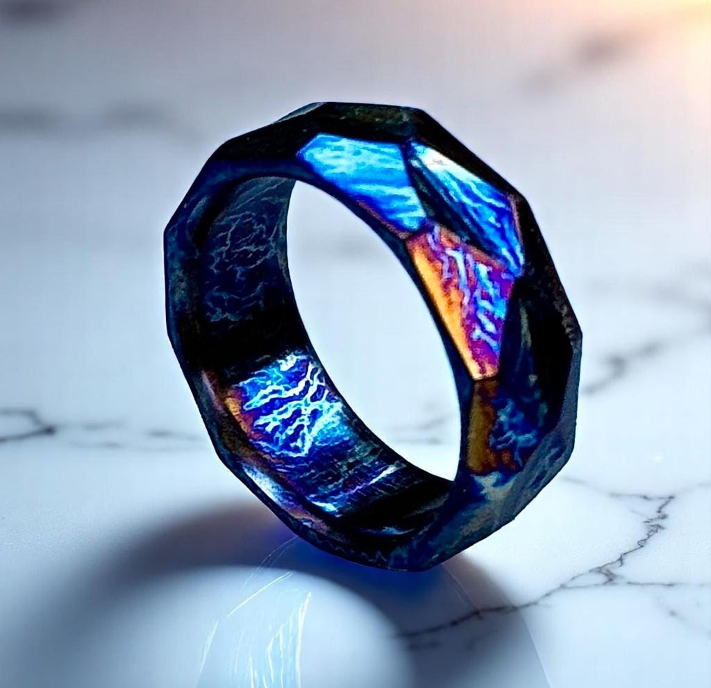 Futuristic ring with glowing blue and purple design on a marble surface