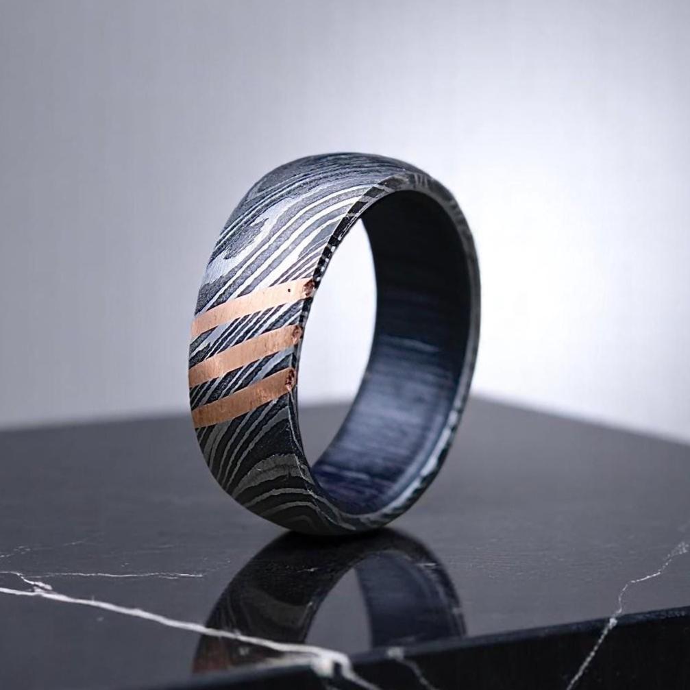 Marbled patterned ring on a reflective surface with a gray background