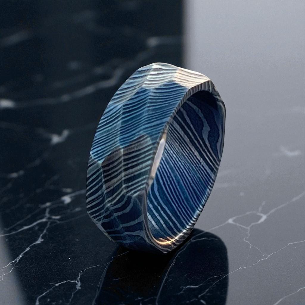 Blue and silver ring on a dark marble surface