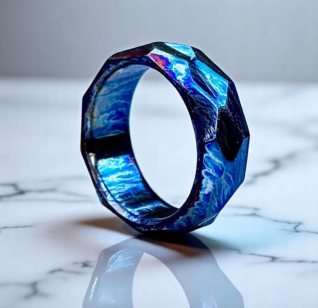 Blue and purple geometric ring on a marble surface