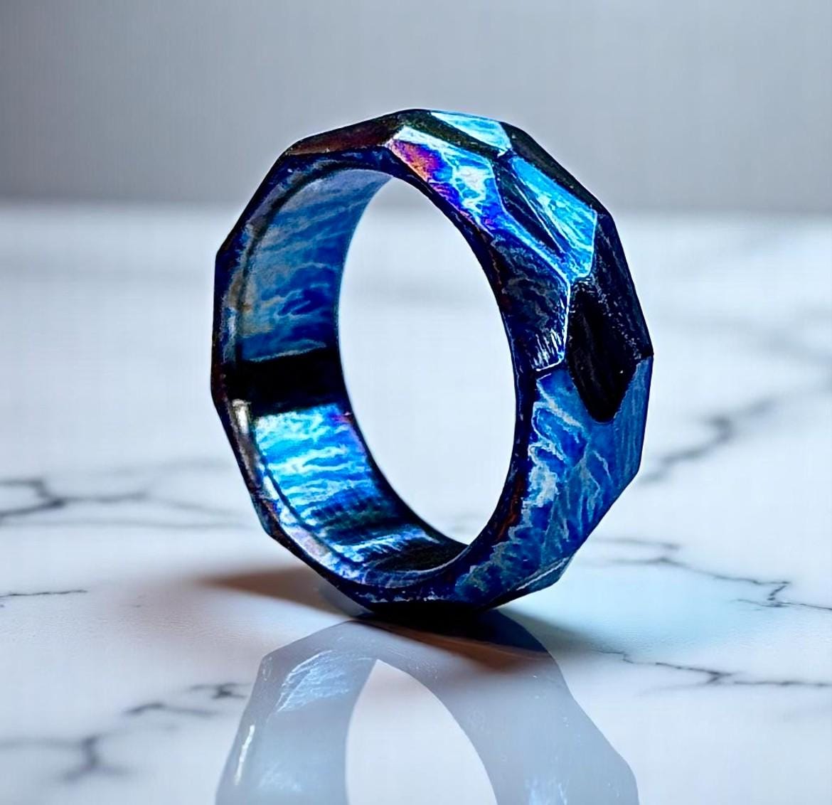 Blue and purple geometric ring on a marble surface