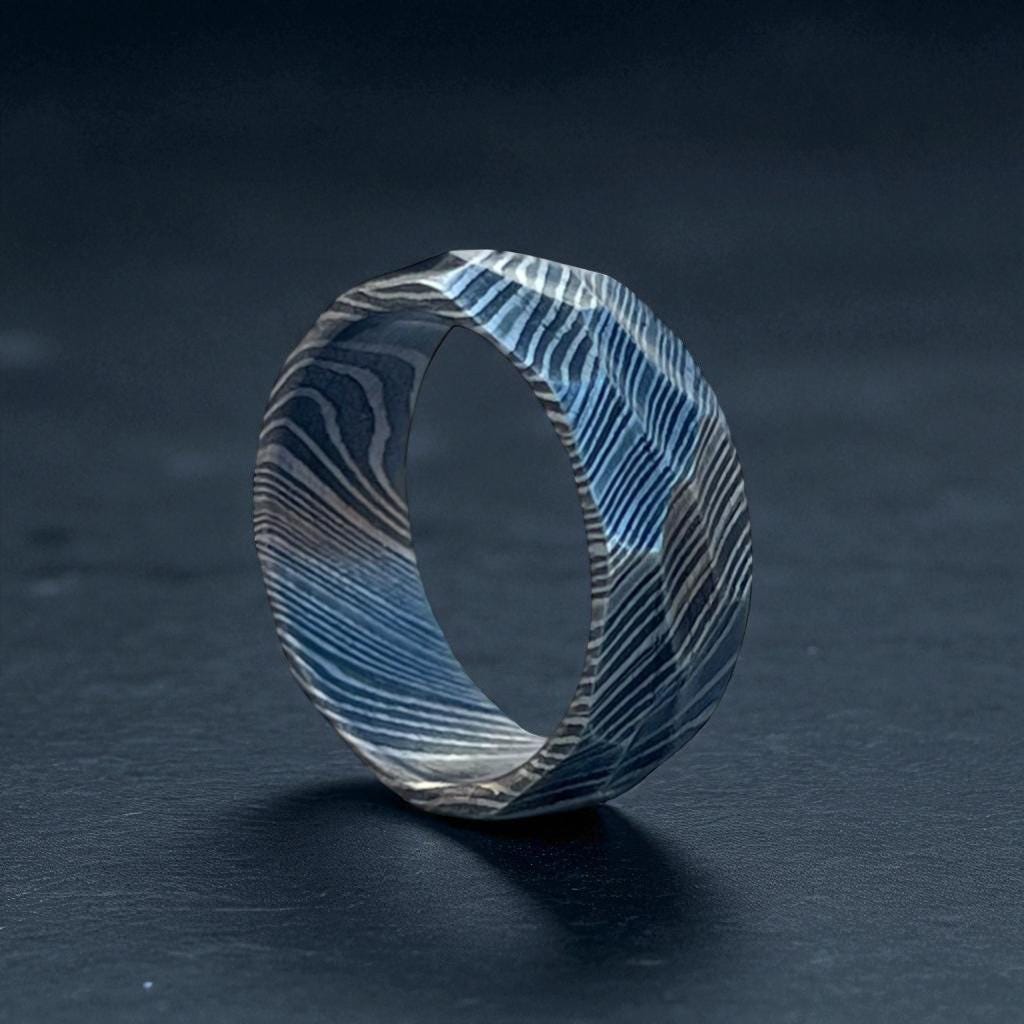 Wooden ring with blue and gray pattern on a dark background