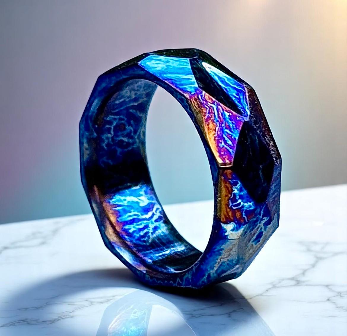 Futuristic ring with blue and purple hues on a marble surface