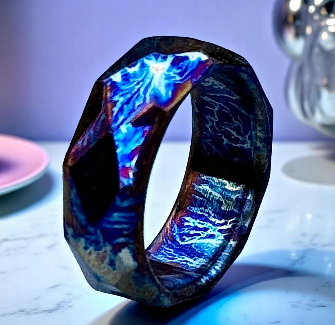 Wooden ring with a glowing blue interior on a marble surface